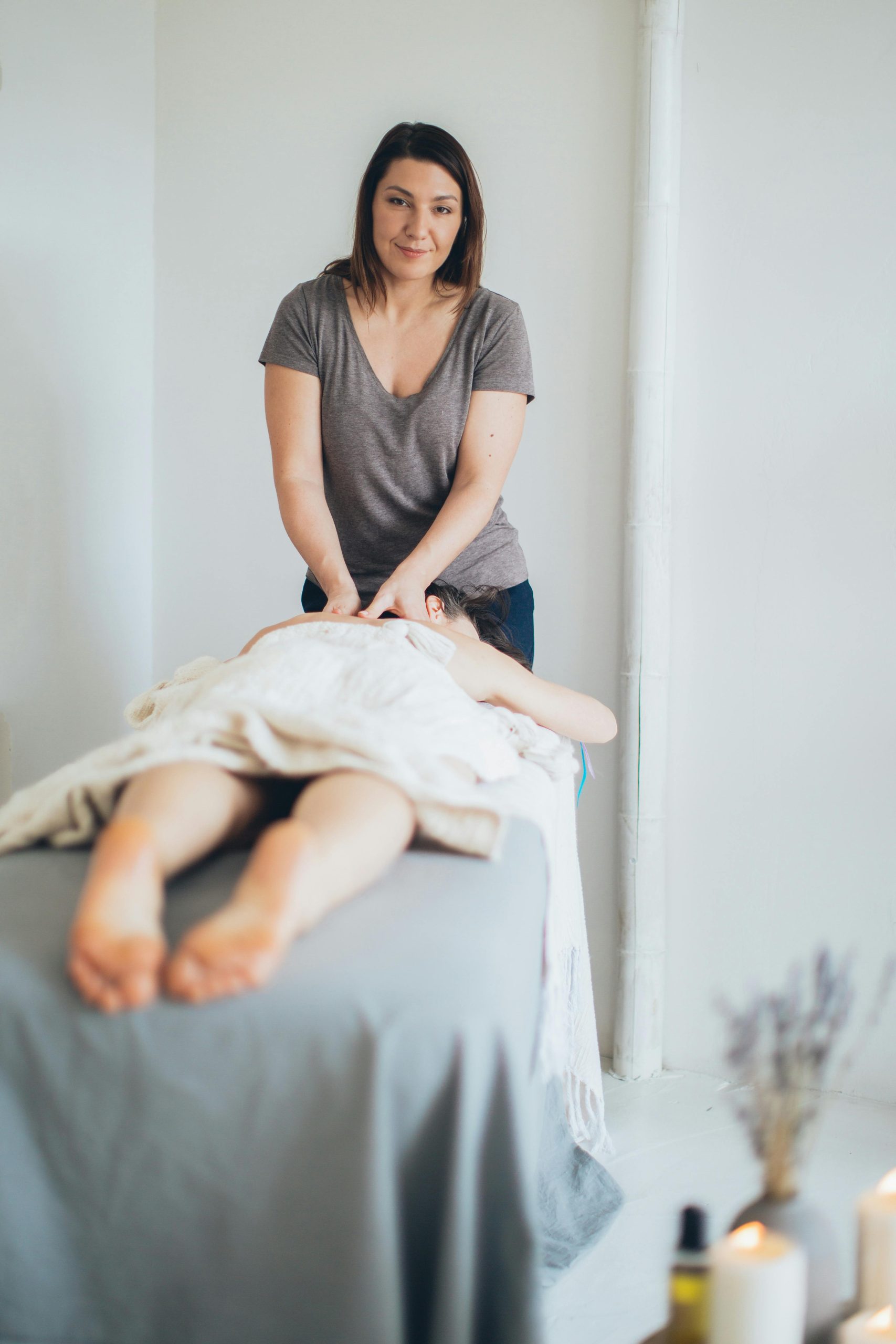 A woman gives a soothing massage in a calming indoor spa setting, promoting relaxation and wellness.