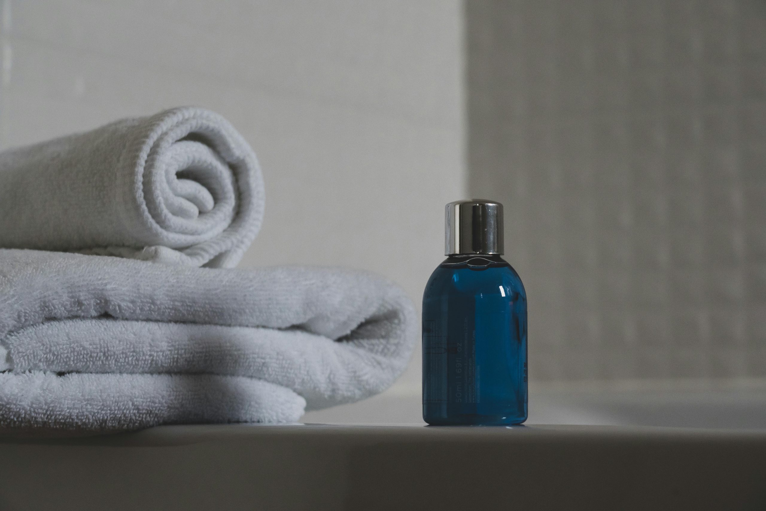 Luxurious white towels and blue bottle create a tranquil spa atmosphere.